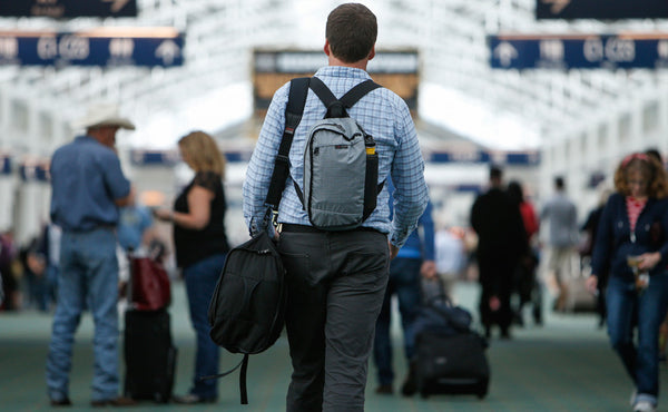 A person carrying the Hero's Journey main bag as a shoulder bag and the Hero's Journey top pocket as a backpack.